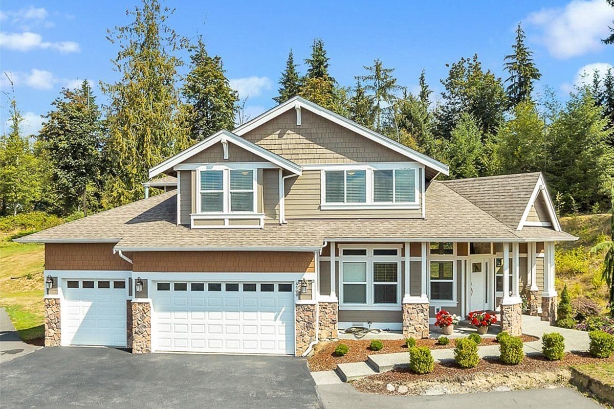 House plan exterior featuring a two-story Craftsman style home with a front-facing garage, gabled roof, and columned front porch.