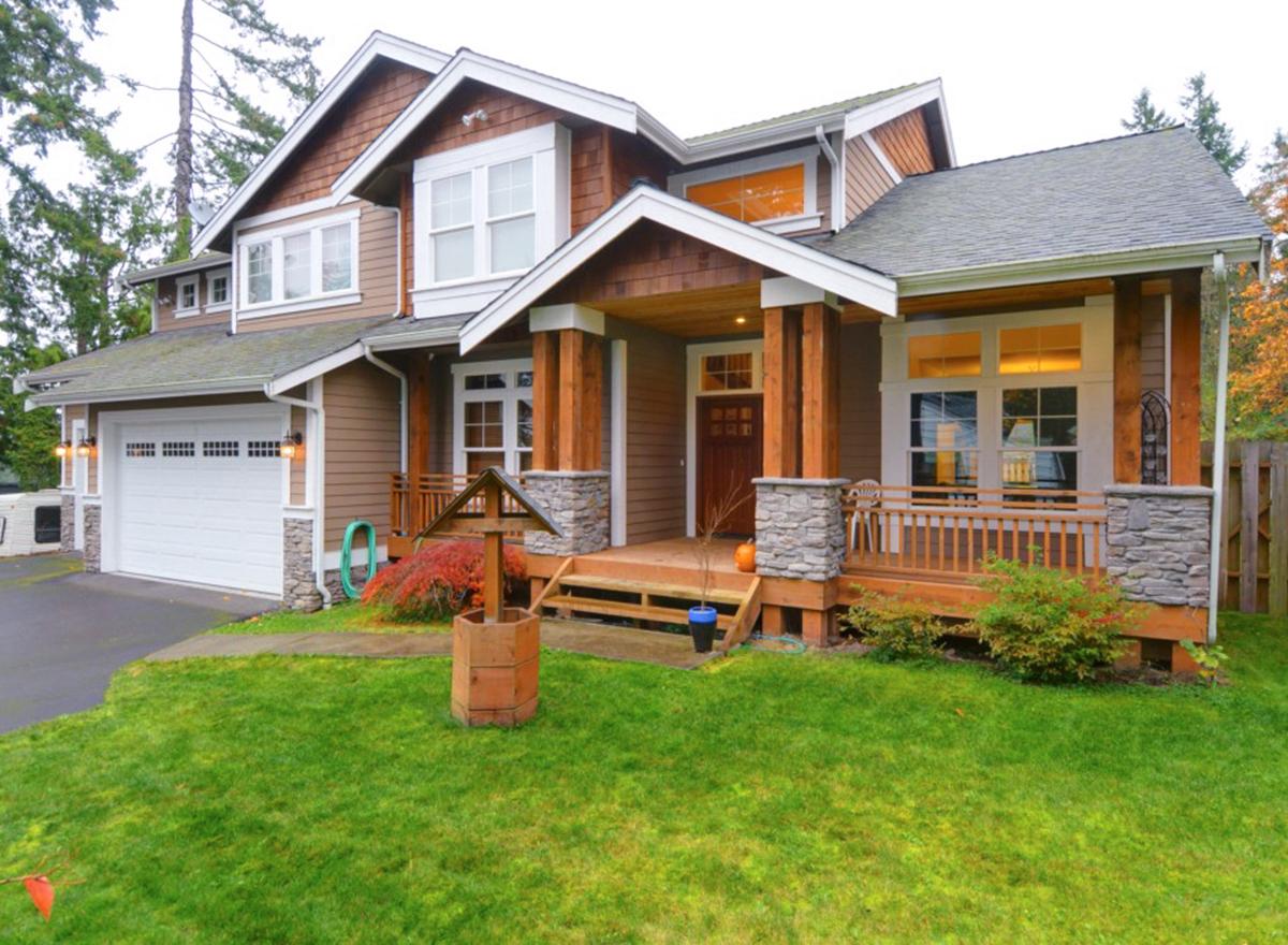 House plan exterior: two-story home with a covered porch, prominent gables, stone accents, and attached garage.