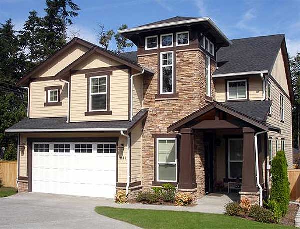 House plan exterior: Two-story home with integrated garage, stone accent on tower, covered entry with tapered columns, and varied rooflines.