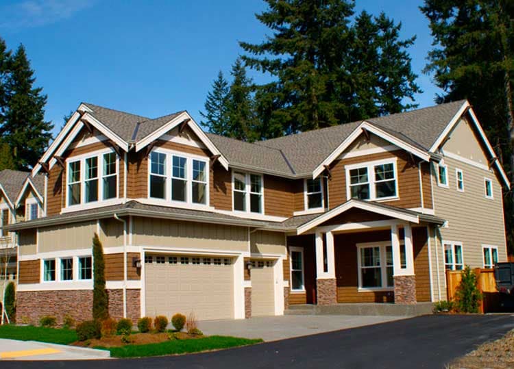 House plan exterior: Two-story Modern Farmhouse with gabled dormers, a covered entry porch, and a three-car garage.