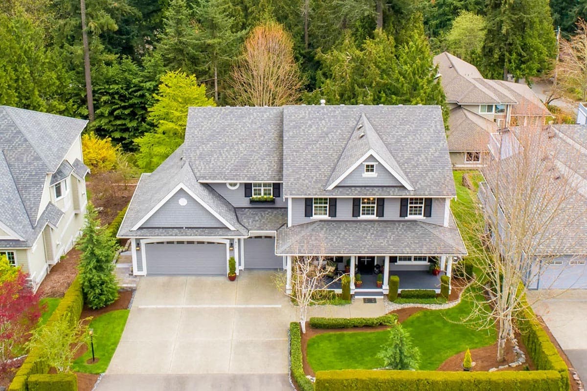 House plan exterior: Two-story residence with a covered front porch, multiple gables, and a three-car garage.