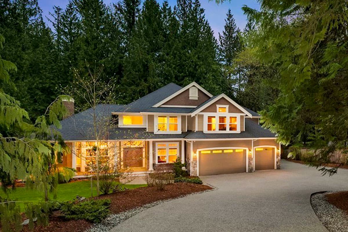 Craftsman style house plan exterior with dark roof, multiple gables, covered porch, and a three-car garage.