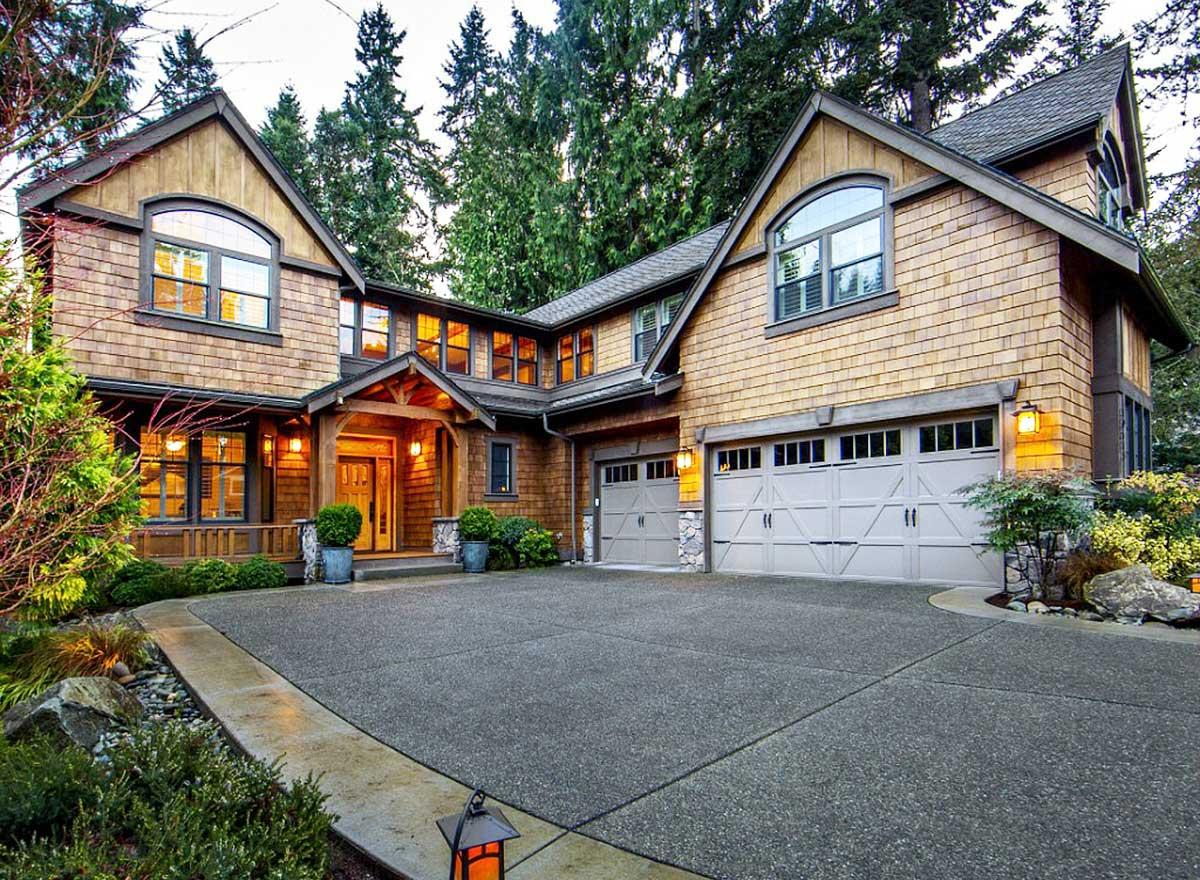 House plan exterior. Craftsman-style home with cedar shake siding, multiple gables, and attached garage. Includes a covered porch and arched windows.