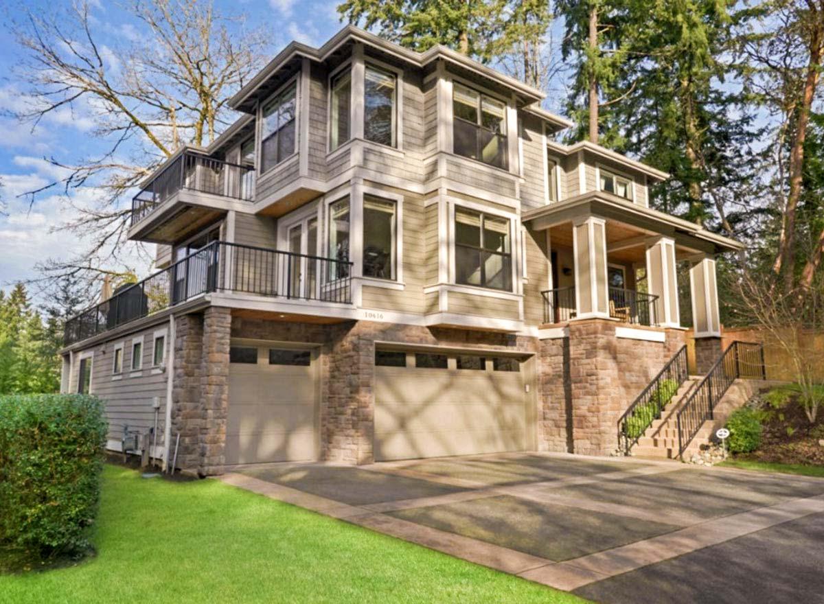 House plan exterior. Multi-story contemporary home with balcony, stone facade, covered entry porch, and attached garage.