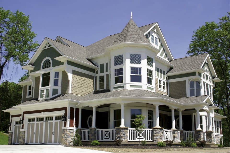 House plan exterior: Victorian style, two stories, turret, wrap-around porch, and multi-material siding.