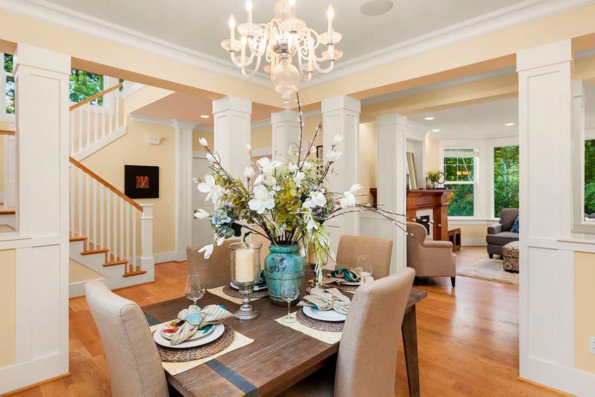 Interior view of a dining room with a staircase, fireplace, and open layout.
