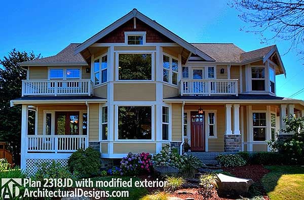 House plan exterior of a two-story home with gabled dormers, multiple bay windows, and a wraparound porch supported by columns.