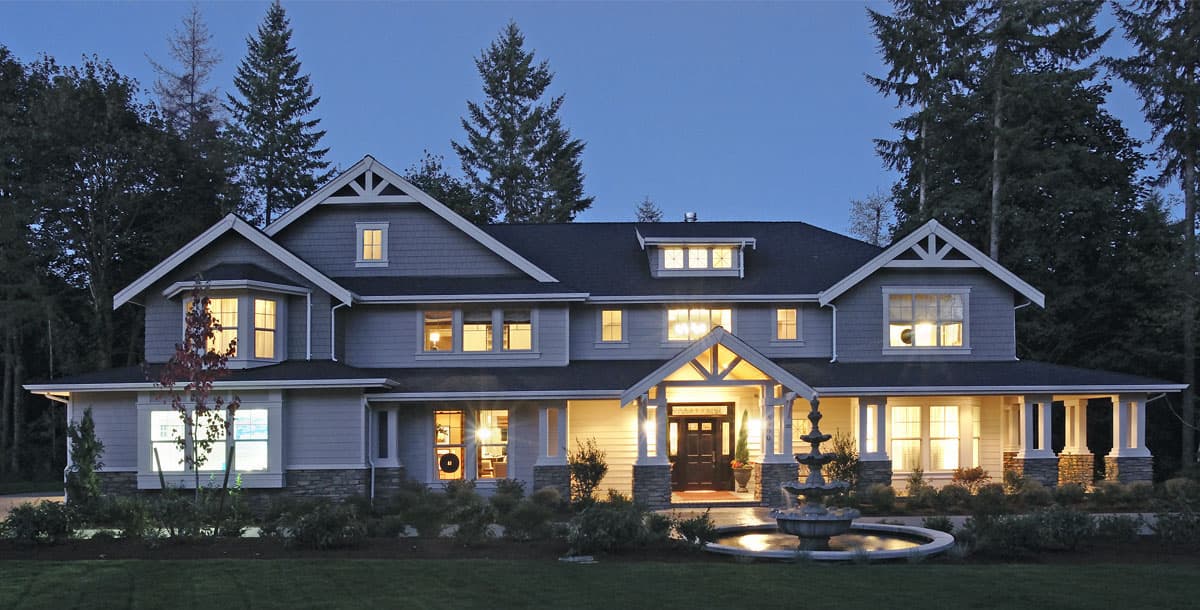 House plan exterior: Two-story Modern Farmhouse with gabled dormers, a covered front porch with stone pillars, and bay windows.