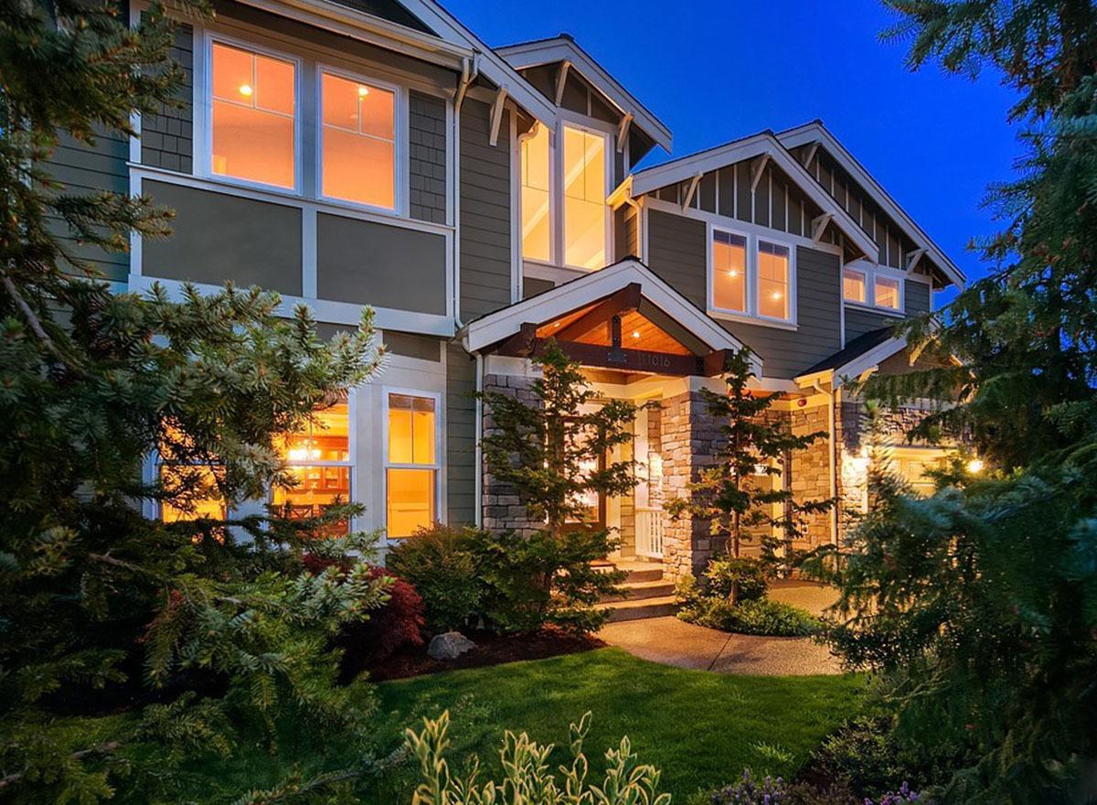 Craftsman style house plan exterior with stone accents, covered porch with exposed beams, gables, and multiple stories.