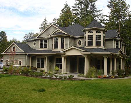 House plan exterior for a two-story home with a wraparound porch, turrets, and gables.