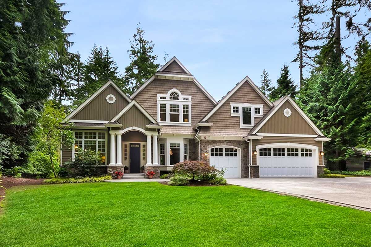House plan exterior. Two-story Craftsman home with gabled roof, columned entry porch, and attached garage. Exterior features shake siding.