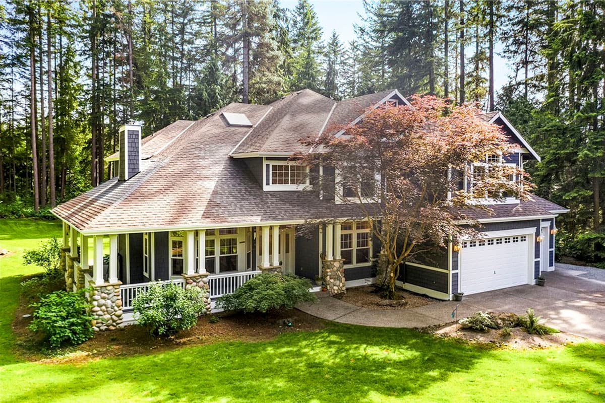 House plan exterior: two-story Modern Farmhouse with wrap-around porch, stone accents, and attached two-car garage.