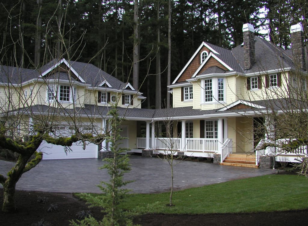 House plan exterior featuring a two-story home with a wraparound porch, dormers, and a detached garage.