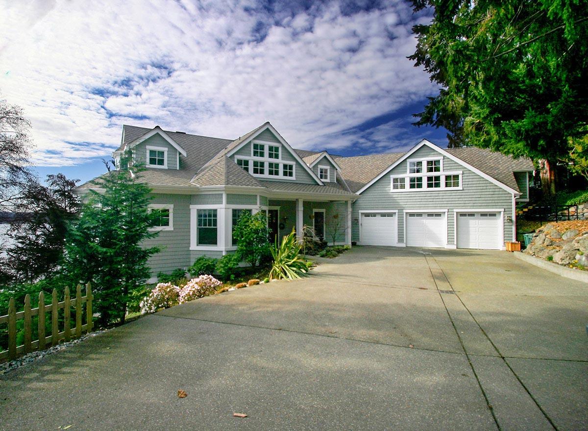 House plan exterior: Coastal style, two stories, prominent gables, dormers, covered entry, and attached three-car garage.
