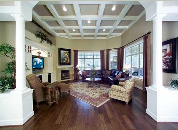Great room with coffered ceiling, fireplace, built-in entertainment center, and bay windows.