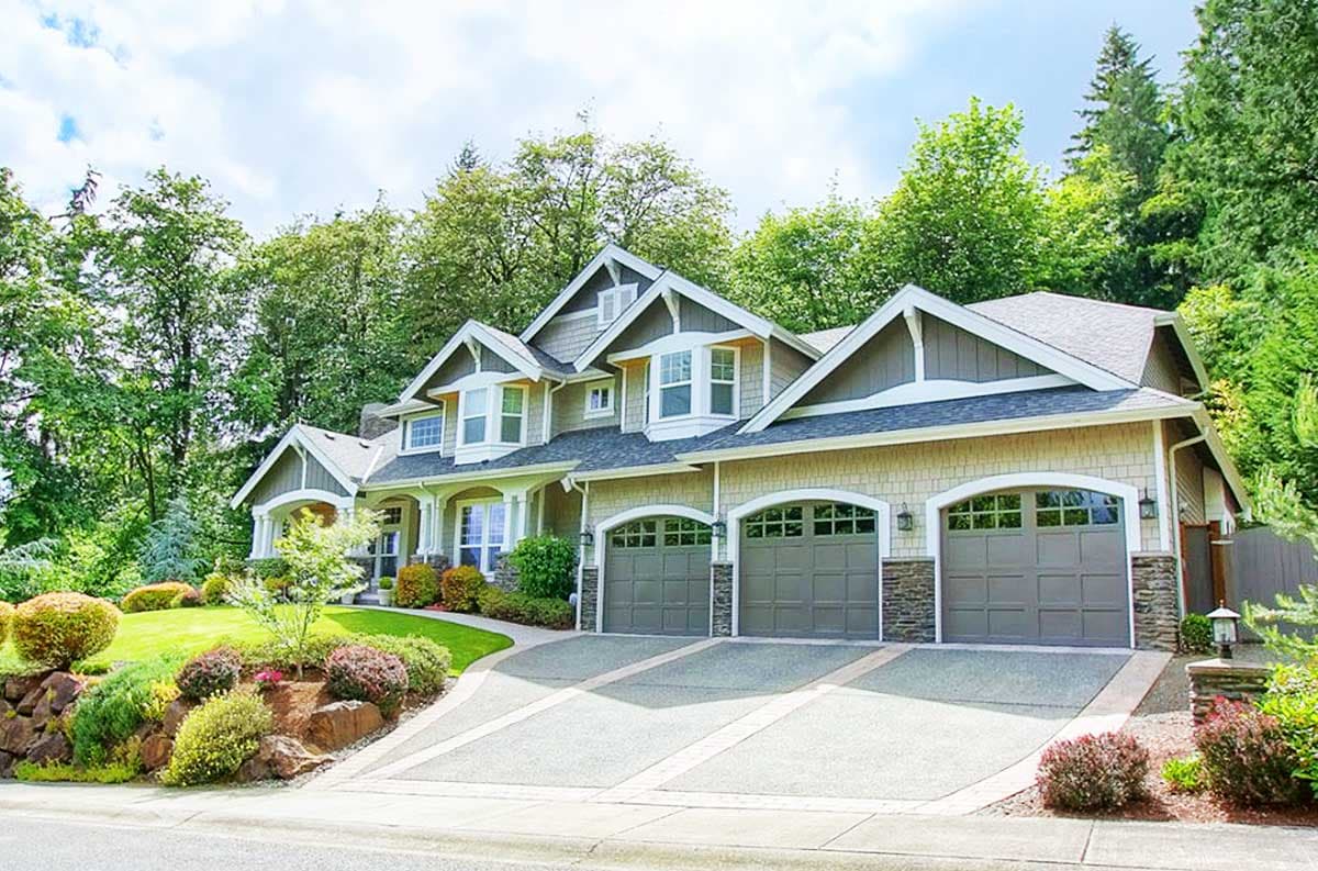 House plan exterior: Two-story home with three-car garage, gables, dormers, and stone accents.