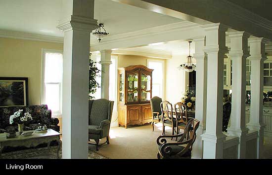 Living room with columns, china cabinet, dining table, and seating area. Open layout.