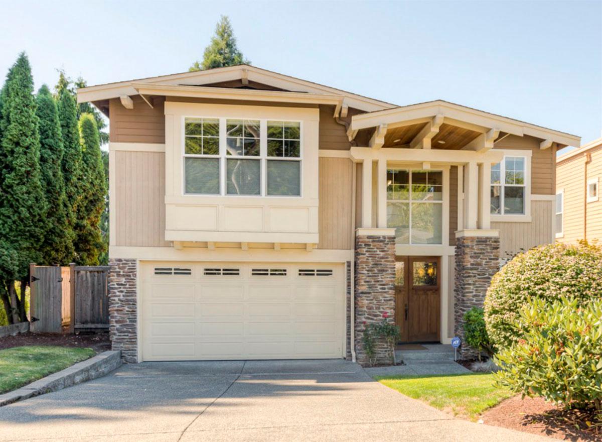 House plan exterior featuring Craftsman-style design. Two-story home with a stone-accented entry, gabled roof, and a two-car garage.