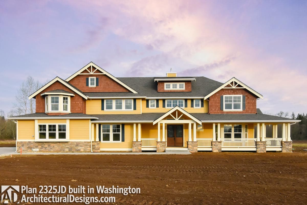 House plan exterior: Two-story Modern Farmhouse with wrap-around porch, stone accents, bay window, and multiple gables.