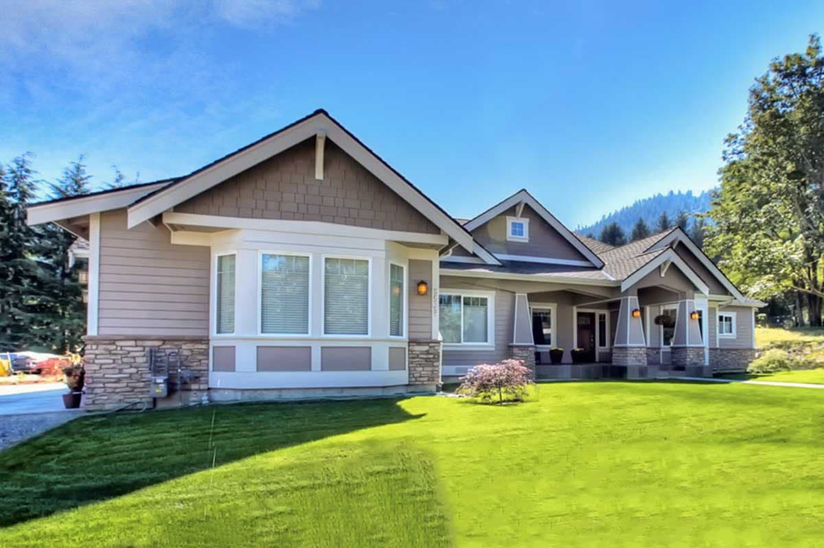 House plan exterior featuring a Craftsman style, wide eaves, bay window, stone accents, and a covered entry with decorative pillars.