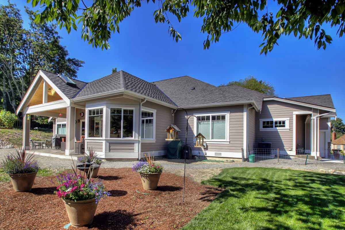 House plan exterior with a covered porch, bay window, gables, and clipped gable roof.