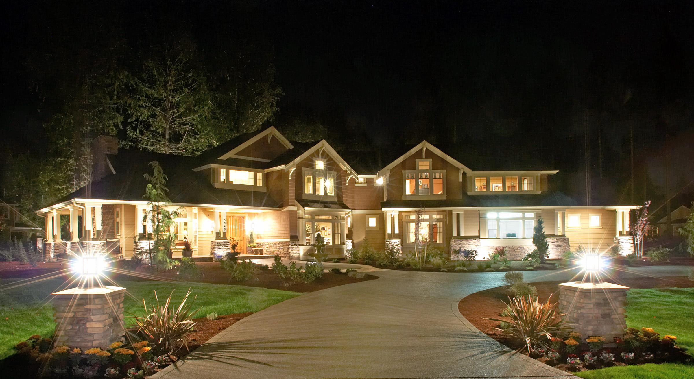 House plan exterior: Craftsman style, two stories, featuring gabled dormers, covered entry porch with stone pillars, and multi-level rooflines.