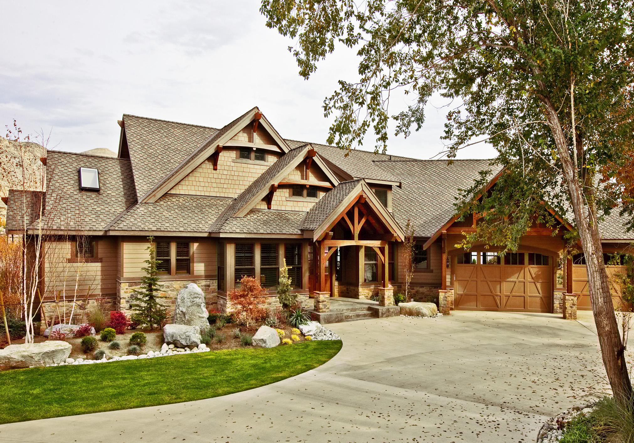 Craftsman style house plan exterior with multiple gables, shingle siding, stone accents, and a three-car garage.