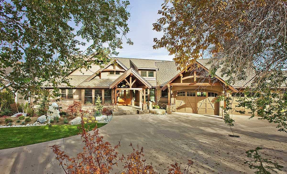 House plan exterior: Craftsman style with exposed timber framing, multiple gables, stone accents, and a three-car garage.