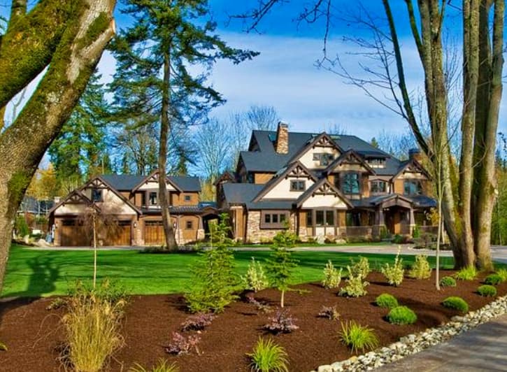 House plan exterior with multiple gables, stone accents, wood trim, dormers, and a three-car garage.