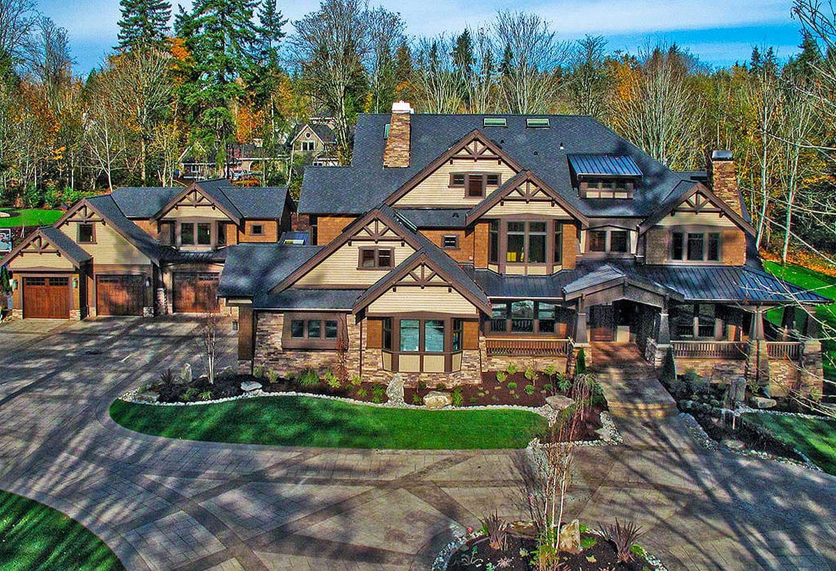 Craftsman style house plan exterior with multiple gables, stone and wood siding, covered entry, and attached garages.