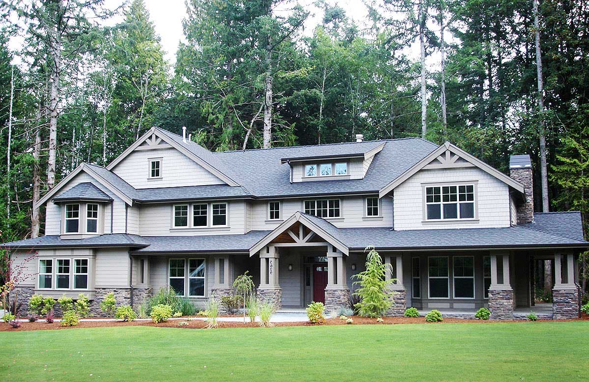 Craftsman style house plan exterior with a covered porch, stone accents, gables, and dormers.