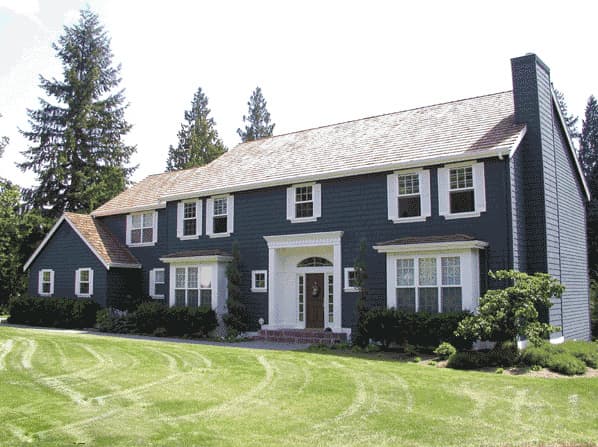 House plan exterior: Two-story dark blue home with white trim, prominent entry portico, bay windows, and large side chimney.