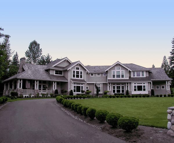Craftsman style house plan exterior, two stories, with a wide wraparound porch, stone chimney, and prominent gables.