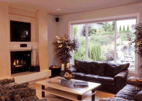 Living room with fireplace, large window overlooking a garden with a waterfall, and leather sofas.