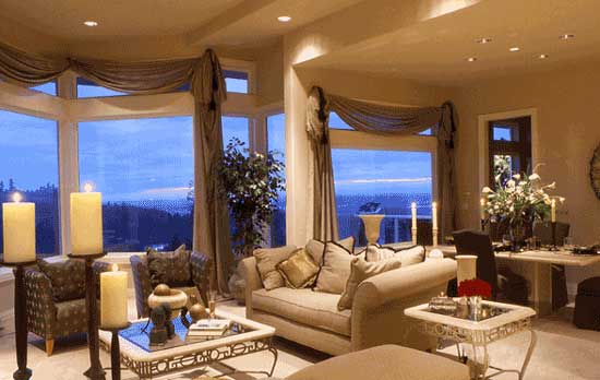 Living room with large windows, sectional sofa, two armchairs, coffee table, and dining area with table and chairs.