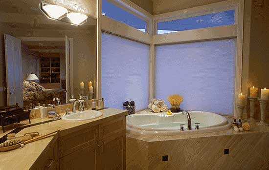 Bathroom with soaking tub, dual sinks, and a mirror reflecting a bedroom with built-in shelving.