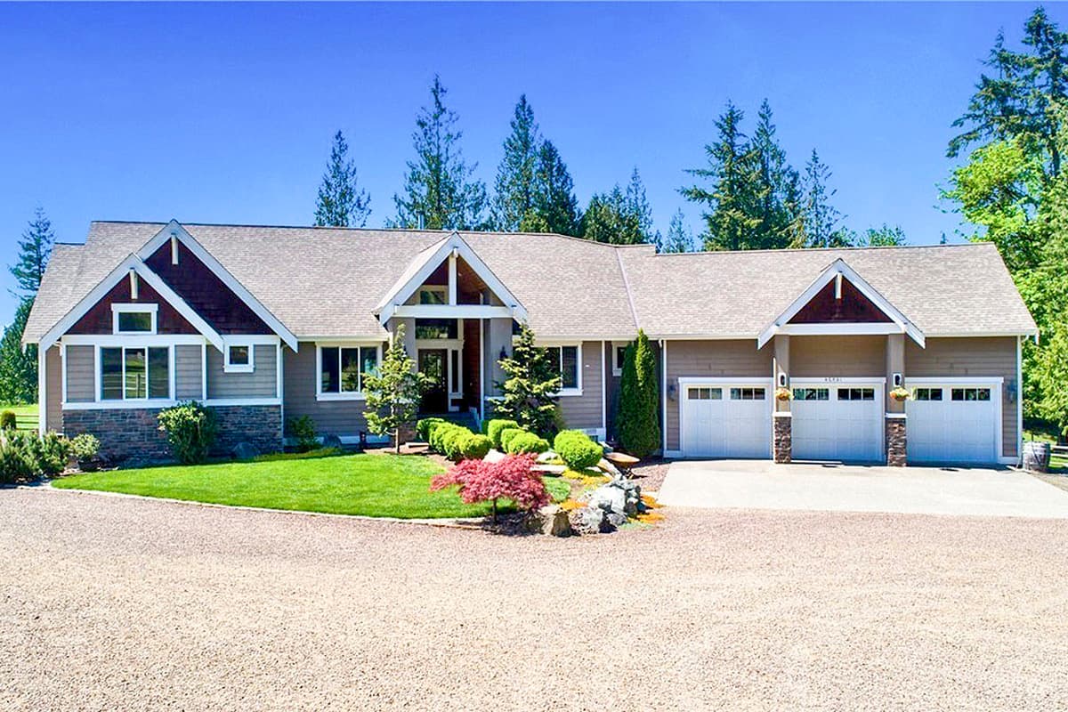 House plan exterior with Craftsman details. Features include gabled roof, mixed siding, and an attached three-car garage. Stone accents at the base.