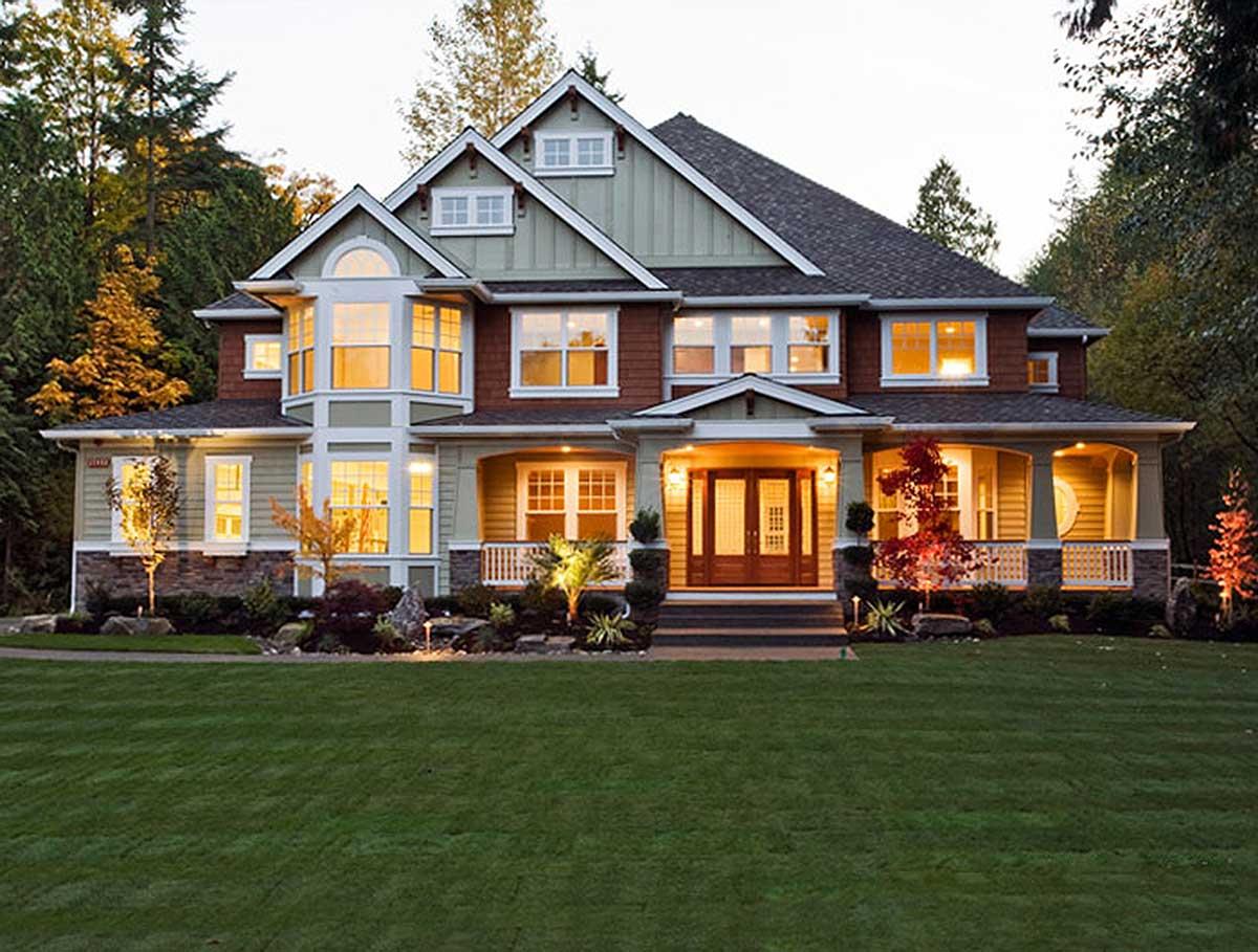 House plan exterior. Two-story Craftsman home with a front porch, gables, dormers, and a multi-paned window design.