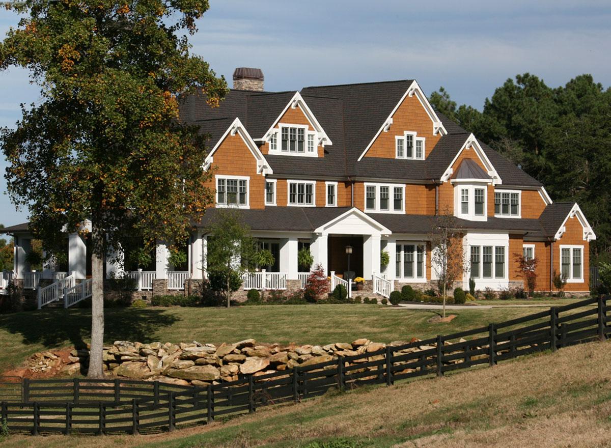 House plan exterior: This large, multi-story home features a wrap-around porch, multiple gables, and shingle siding.
