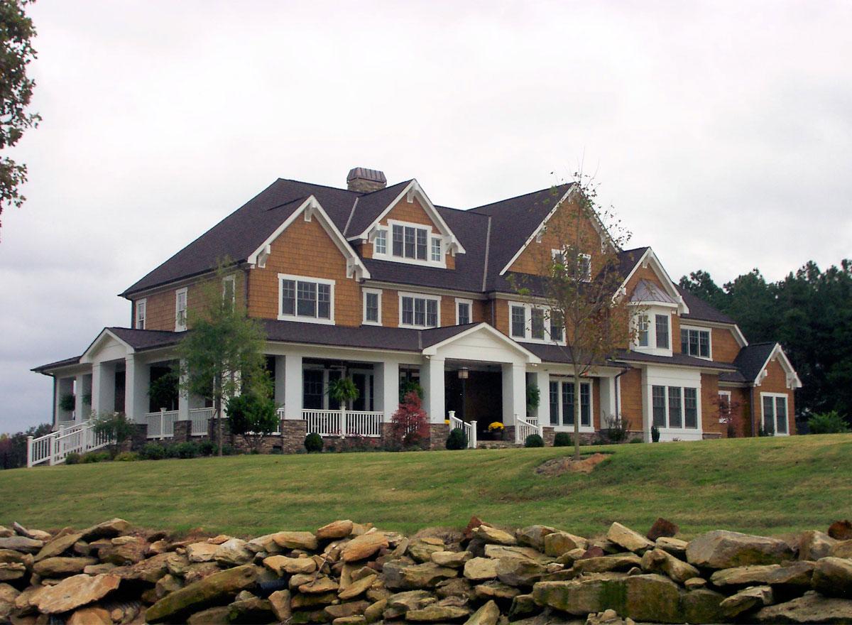 House plan exterior: Two-story Modern Farmhouse with wrap-around porch, gables, and stone accents.