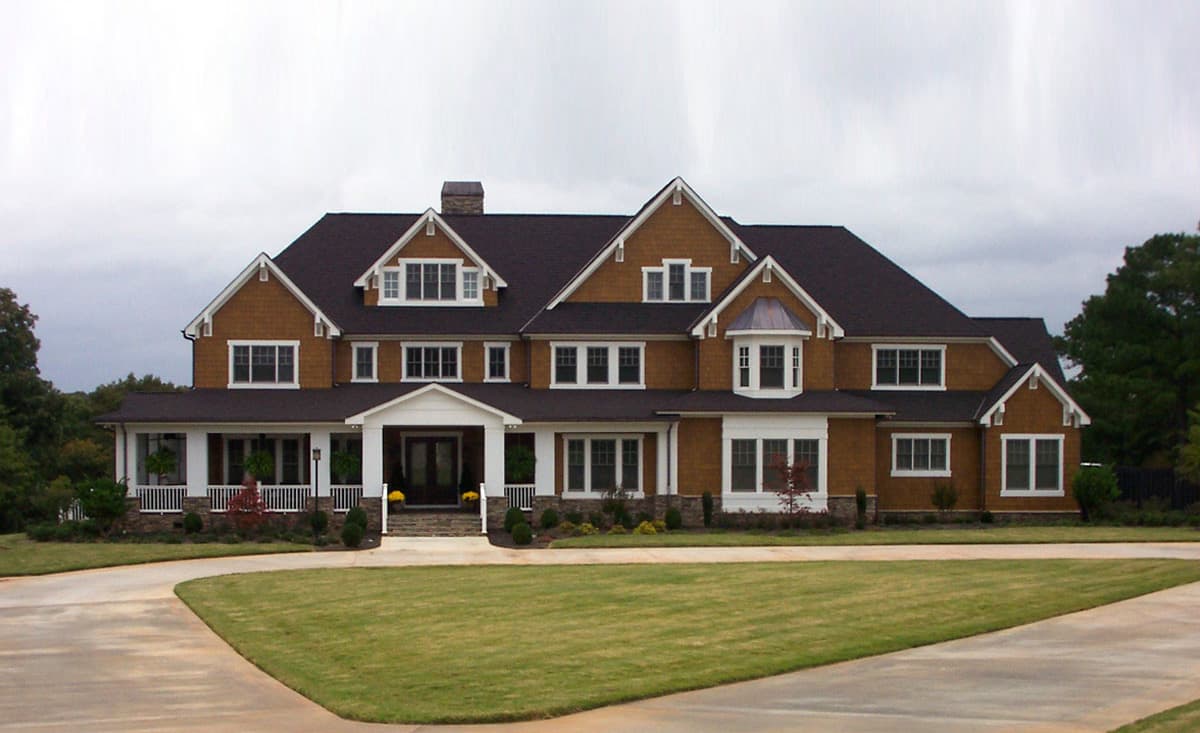 House plan exterior: Two-story home with wrap-around porch, multiple gables, and dormers.