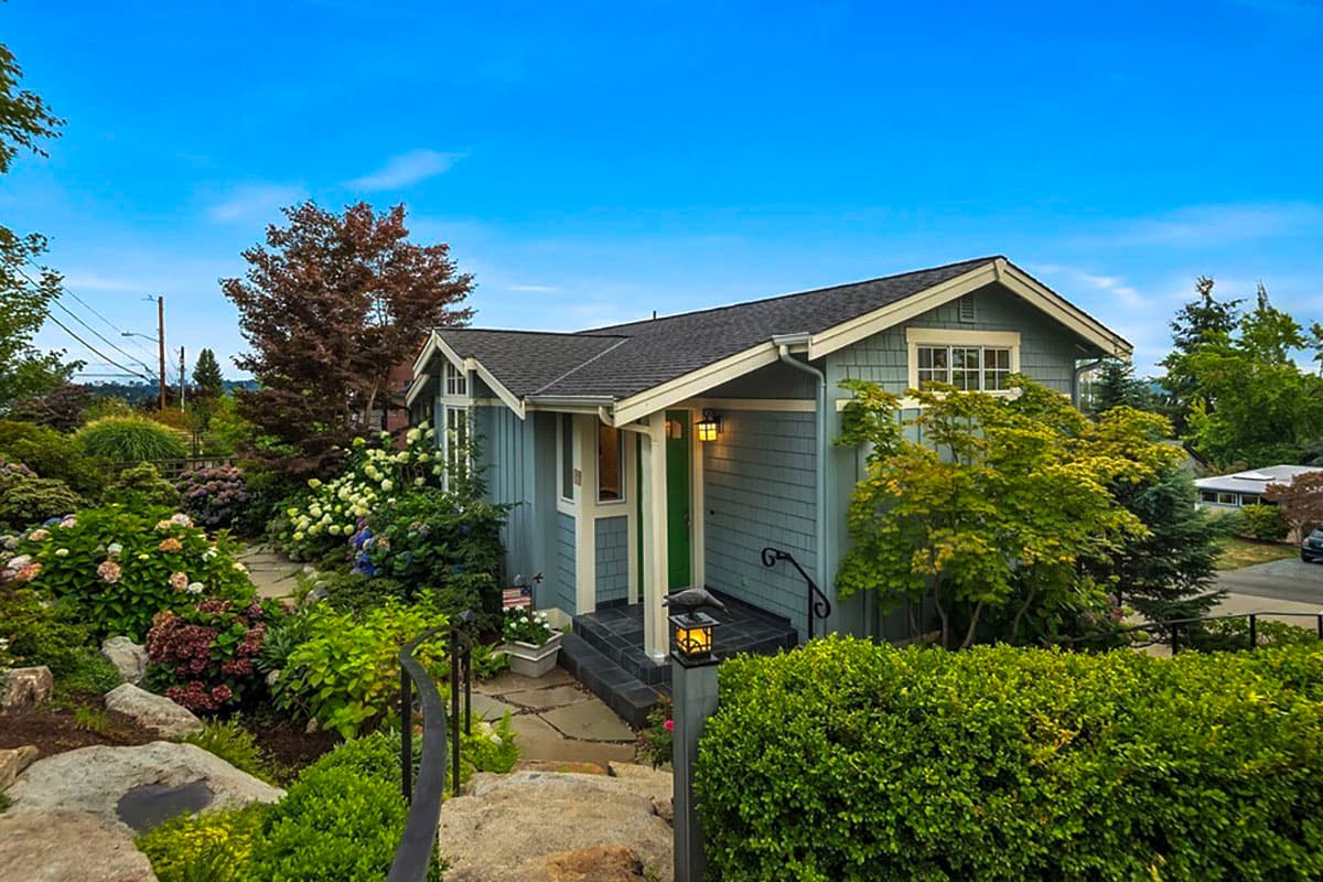 Craftsman style house plan exterior with a covered entry porch, dormers, and clapboard siding.