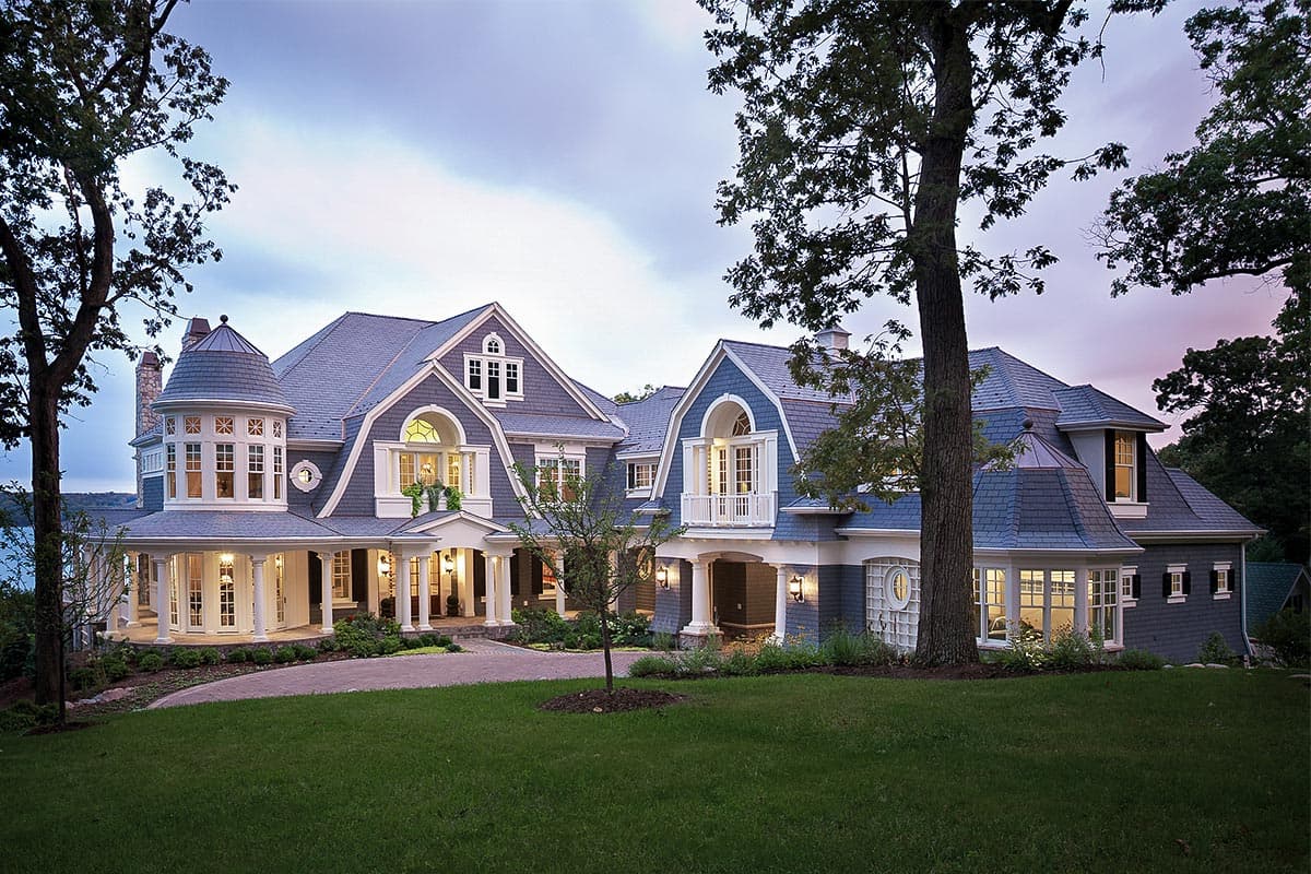 House plan exterior with turret, porte-cochère, gables, dormers, and wraparound porch. (115 characters)