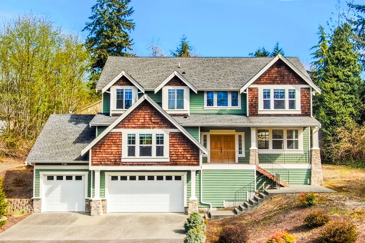 House plan exterior: Two-story Modern Farmhouse with triple gable, wood shingle siding, and a three-car garage.