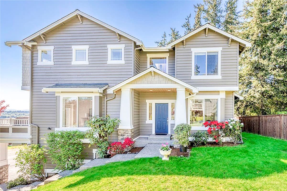 Two-story house plan exterior featuring a covered entryway, prominent gables, multiple dormers, and bay windows.