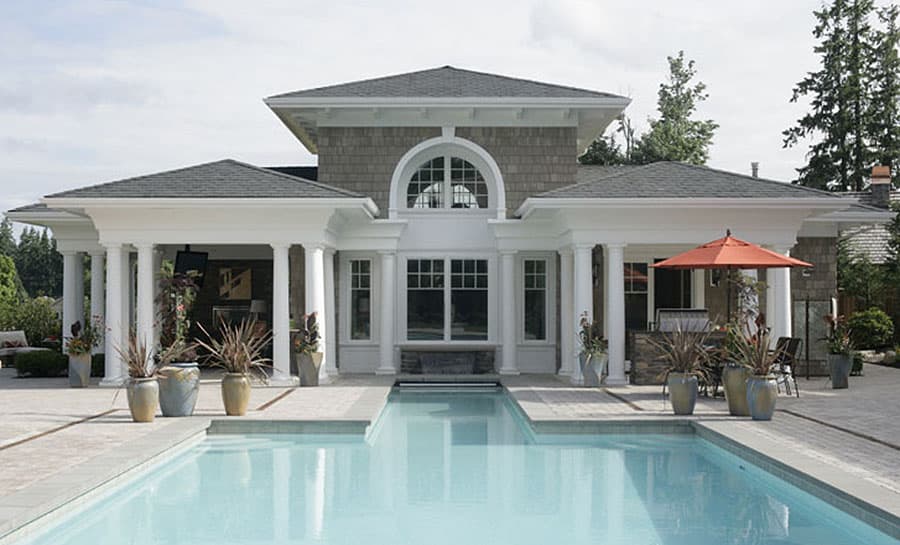 House plan exterior with a large arched window, double-story columns, gabled roof, and poolside patio.
