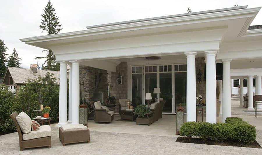 House plan exterior featuring a covered patio with columns, stone accents, and large glass doors.