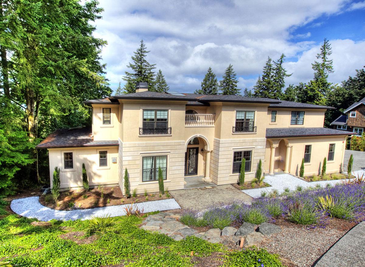 House plan exterior, two stories, arched entry, second-story balcony, stucco finish, stone accents.