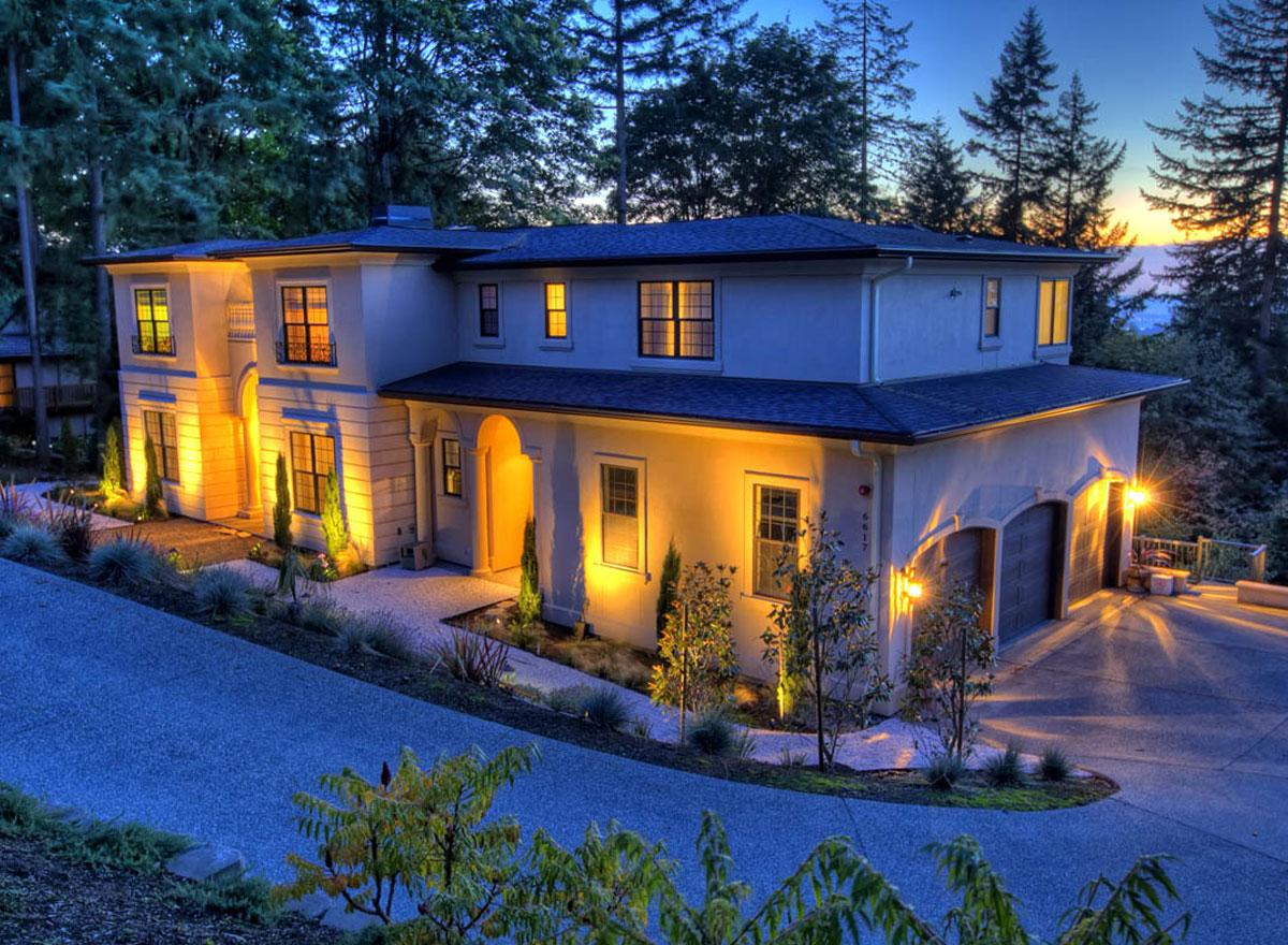 Two-story stucco house plan exterior with arched entryway, garage, and multiple gables.
