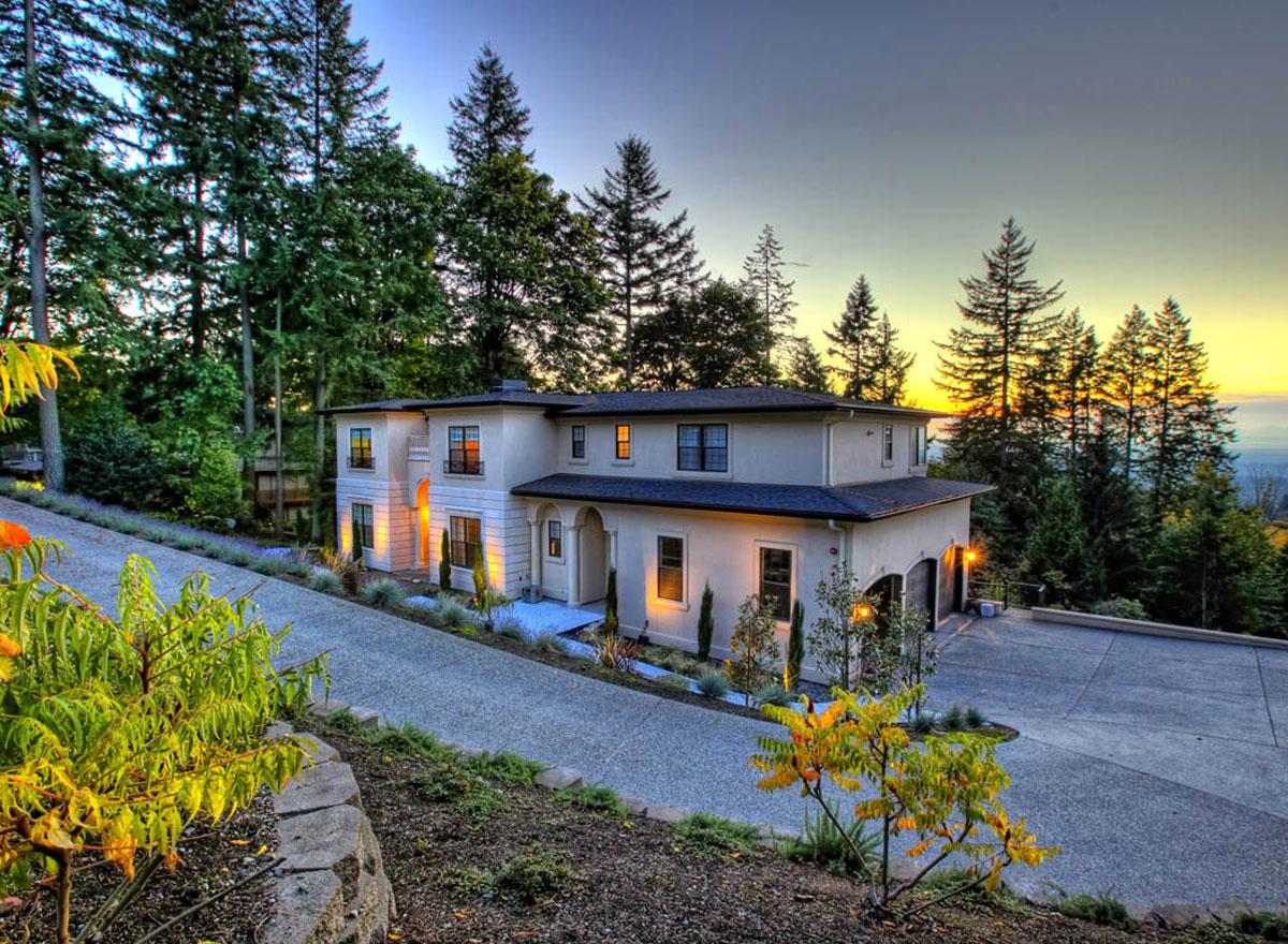 House plan exterior: Two-story contemporary home with stucco facade, flat roof, arched entryway, and attached garage.
